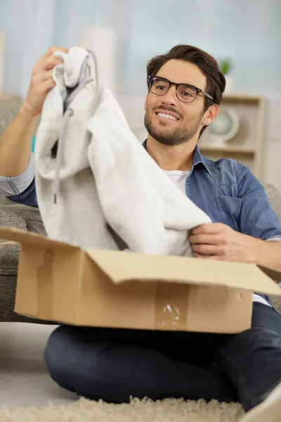 Hombre empezando a vender ropa de negocios en línea accesorio en todo el mundo —  Fotos de Stock