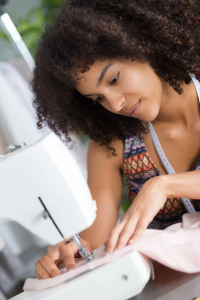 Jonge vrouwelijke mode-ontwerper werkt op naaimachine — Stockfoto