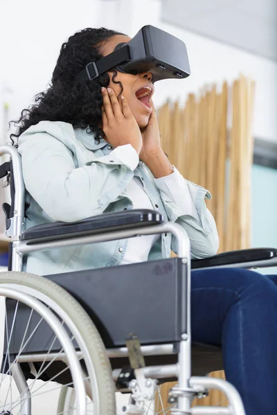 Lycklig kvinna i rullstol gör en virtuell verklighet upplevelse — Stockfoto