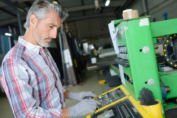 Travailleur opérant la machine en usine — Photo