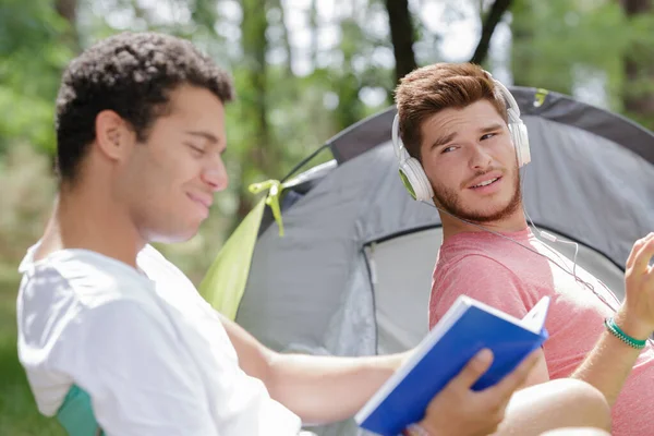 Vrienden met verschillende vrijetijdsbesteding op de camping — Stockfoto