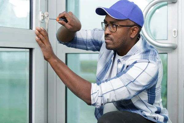 Man werken fittingen op een venster — Stockfoto