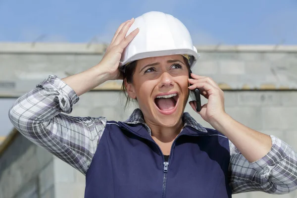 Vrouwelijke bouwer ongelukkig op telefoon — Stockfoto