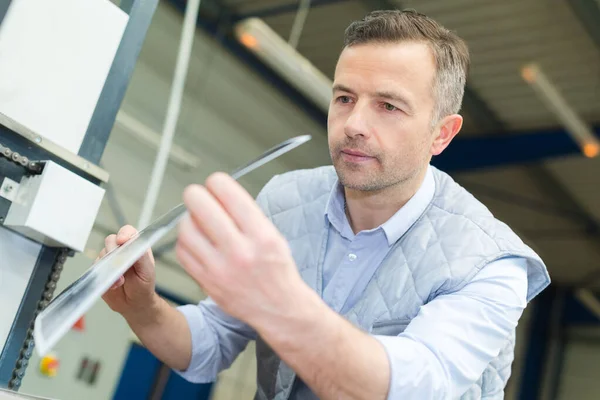 Printing press industrial worker inspecting gloss paper — Stock Photo, Image