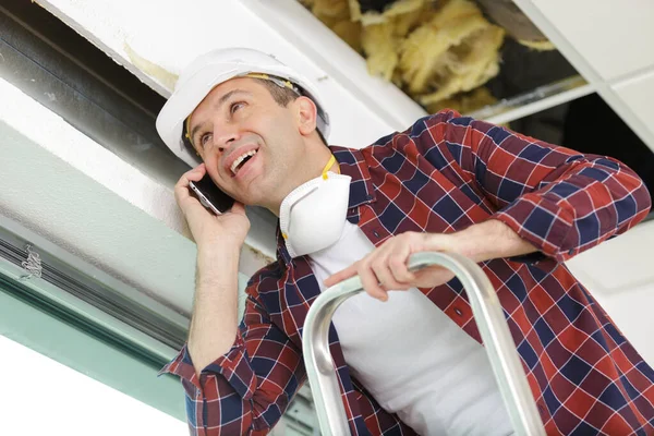 Um homem está reparando teto — Fotografia de Stock