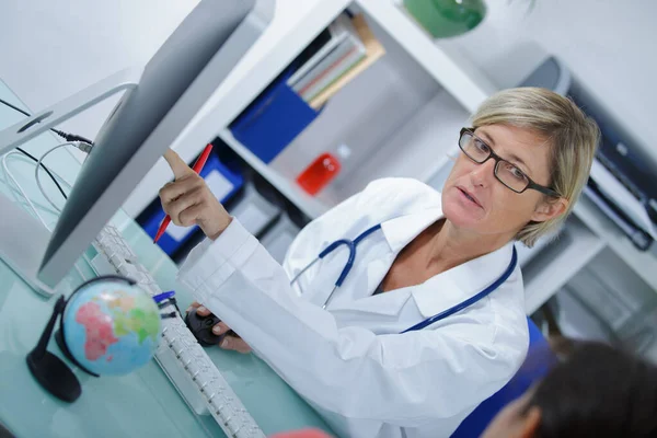 Kobieta lekarz wskazując na komputer — Zdjęcie stockowe
