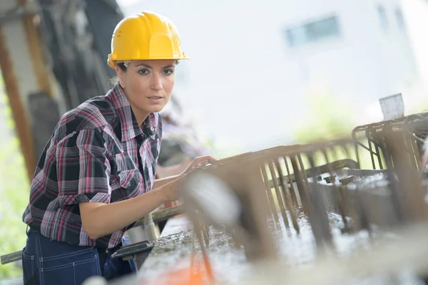建設現場にパイプを持つ自信に満ちた女性労働者 — ストック写真