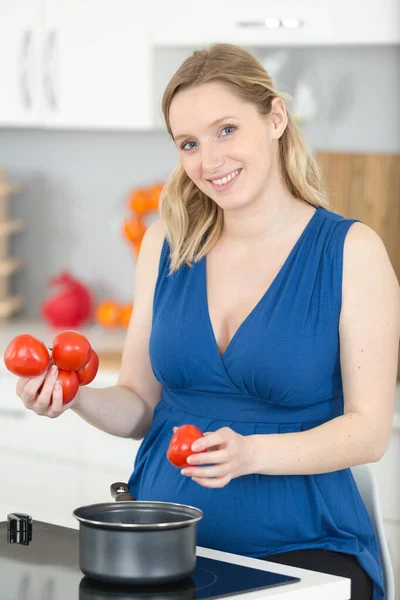 Mujer embarazada preparando ensalada en la cocina —  Fotos de Stock