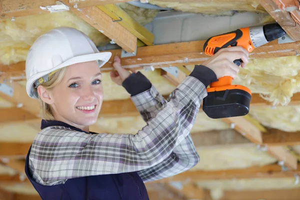 Construction féminine heureuse à l'aide d'une perceuse — Photo