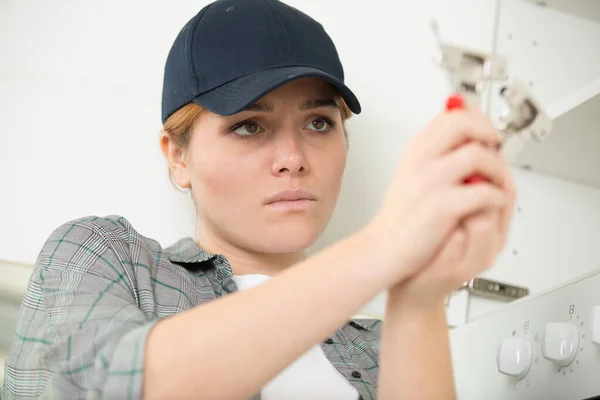 Donna che assembla una mensola bianca — Foto Stock