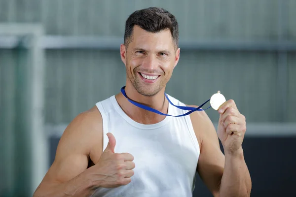 Portrait of handsome sportsman showing medal — Stock Photo, Image