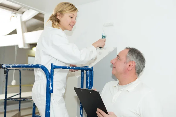 Workman talks to female painter — Stock Photo, Image