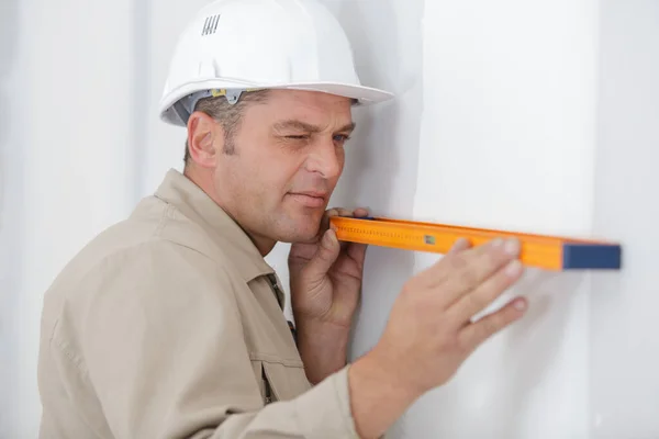 Retrato de homem construtor trabalhando com nível de espírito — Fotografia de Stock