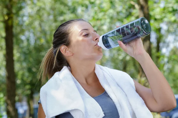 Una giovane donna sta bevendo acqua — Foto Stock