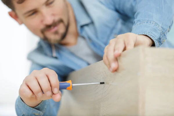 Man screwing bood board with screwdriver — Stock Photo, Image