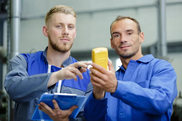 Twee mannen die de spanning van het computerbord meten — Stockfoto