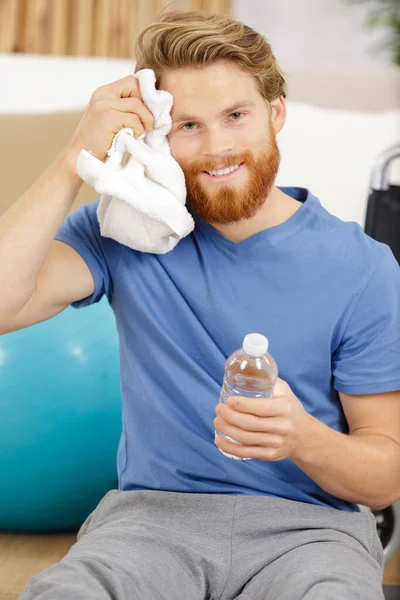 Musculoso joven beber agua en el gimnasio — Foto de Stock