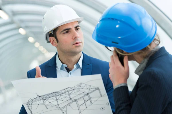 Mannelijke en vrouwelijke ingenieurs aan het praten — Stockfoto