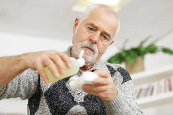 Médico senior desinfectando sus manos — Foto de Stock