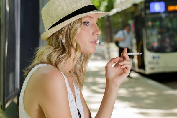 Kouření žena čeká na autobus — Stock fotografie