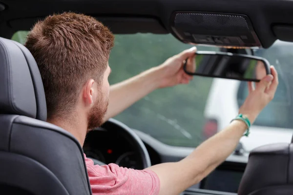 Jeune homme montage rétroviseur dans la voiture — Photo