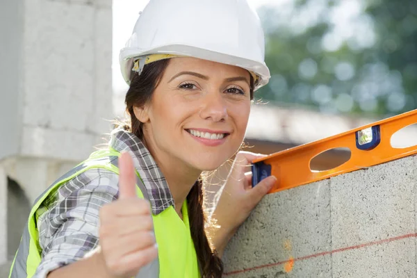 Vrouwelijke metselaar met duim omhoog — Stockfoto