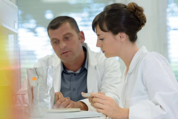 Cientistas examinando no laboratório com tubos de ensaio — Fotografia de Stock