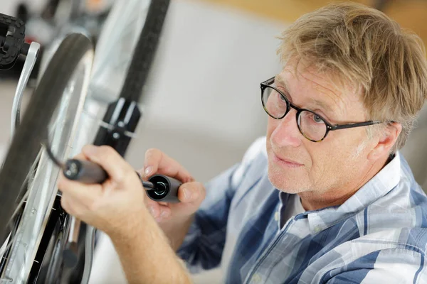 Mann pumpt Fahrradreifen auf — Stockfoto
