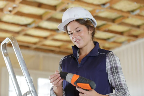 Kvinnlig entreprenör förbereder sin uppladdningsbara borr — Stockfoto