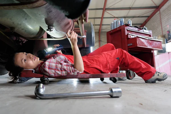 Female mechanic underneath a car — Stock Photo, Image