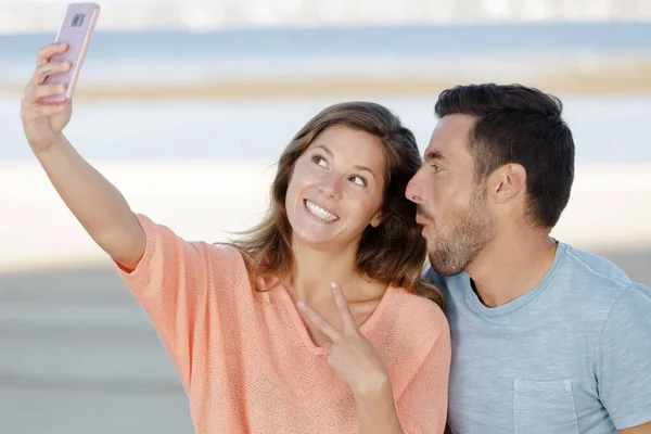 Giovane coppia prendendo un selfie sciocco sul loro balcone giardino — Foto Stock