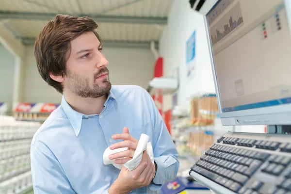 Ständiga business man som arbetar på datorn i ett lager — Stockfoto