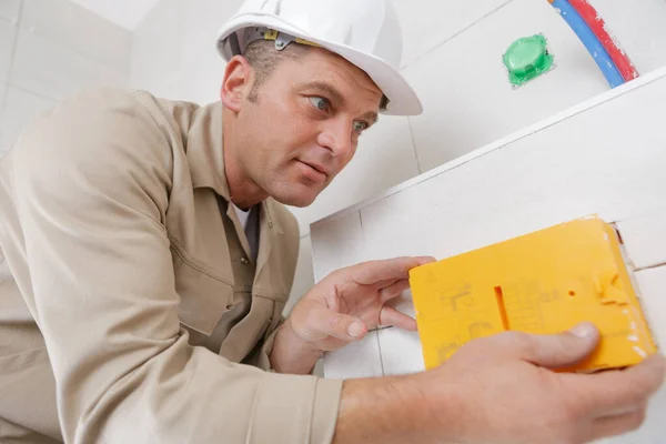 A male worker grouting tiles — Stockfoto