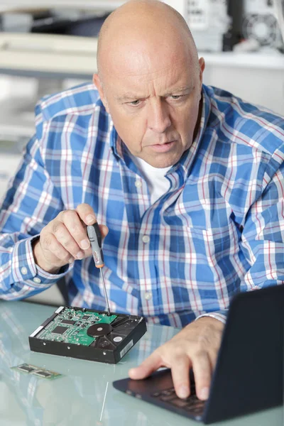 Mature technician with broken hard drive — Stock Photo, Image