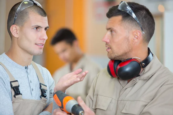 Twee werknemers die een gesprek voeren — Stockfoto