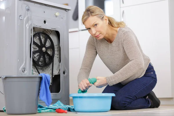 Αναστατωμένη ηλικιωμένη γυναίκα με σπασμένο πλυντήριο ρούχων — Φωτογραφία Αρχείου