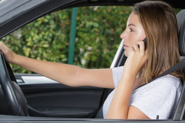 Kvinnlig förare som använder sin telefon under körning — Stockfoto