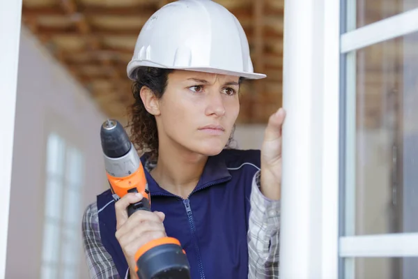 Donna muro di perforazione in una nuova casa — Foto Stock