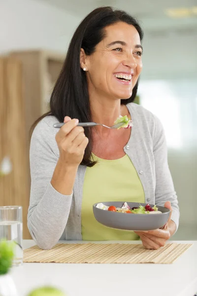 Fit woman eating healthy salad after workout — Stock Photo, Image