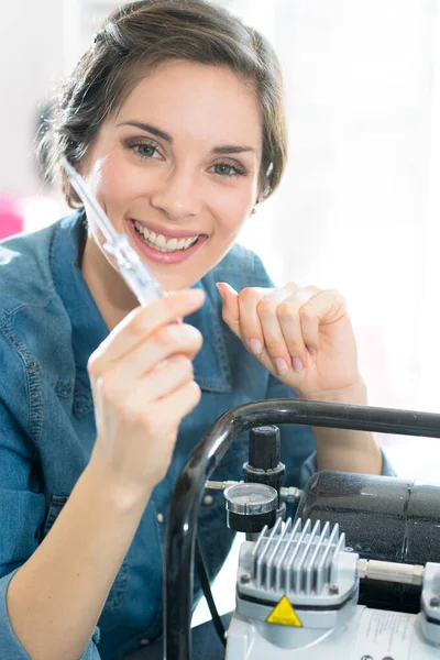 Retrato de mulher segurando chave de fenda ao lado do gerador — Fotografia de Stock