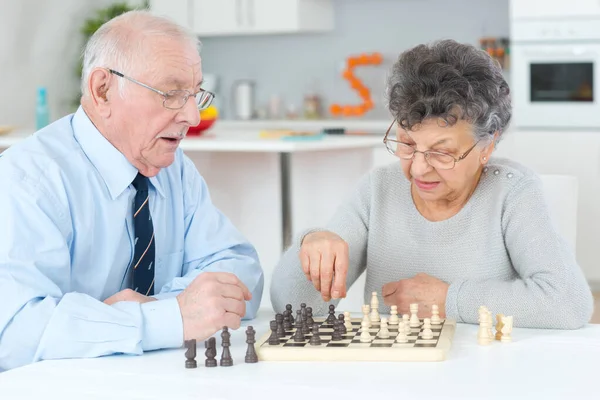 Casal sênior jogando xadrez em uma casa de repouso — Fotografia de Stock