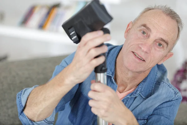Senior man holding vacuum cleaner on one knee cut out — Stock Photo, Image