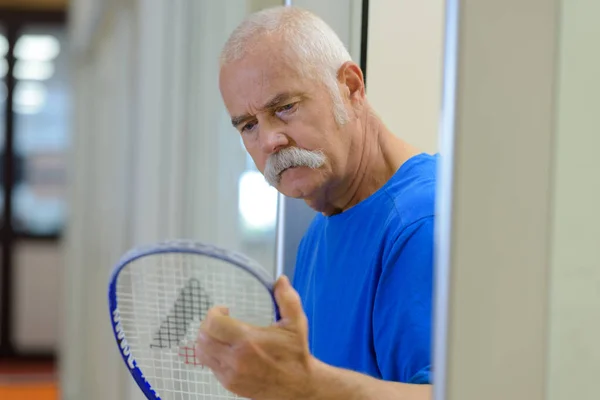 Senior med ketsjer og tennisbold Royaltyfrie stock-fotos