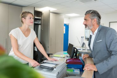 receptionist talking to client while making photocopies clipart