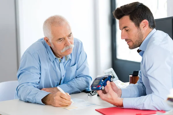 Erfaren senior ingenjör konsulterar ung designer om projekt — Stockfoto