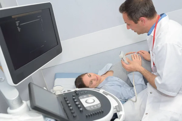 Médico garantindo a mulher grávida antes do ultra-som — Fotografia de Stock