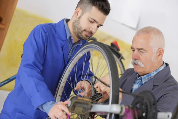バイク ガレージで働く 2 人の自転車修理の同僚 — ストック写真
