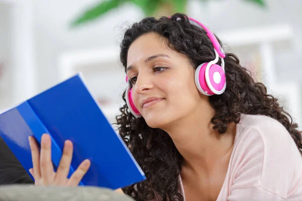 Kobieta czytająca książkę podczas słuchania muzyki — Zdjęcie stockowe
