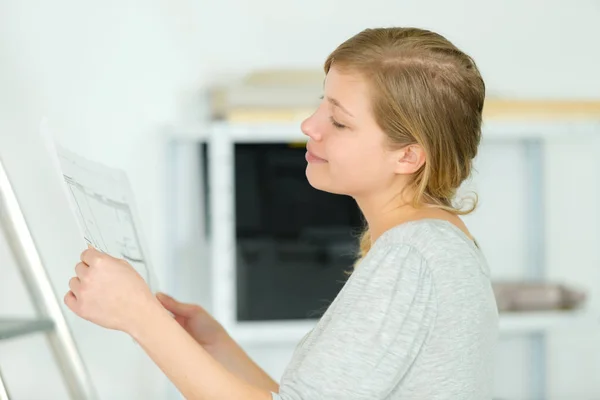 Vrouw controleert de plannen van haar huis — Stockfoto