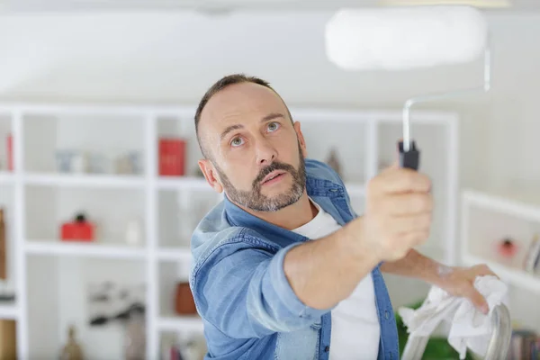 Mężczyzna za pomocą rolki do malowania sufitu — Zdjęcie stockowe